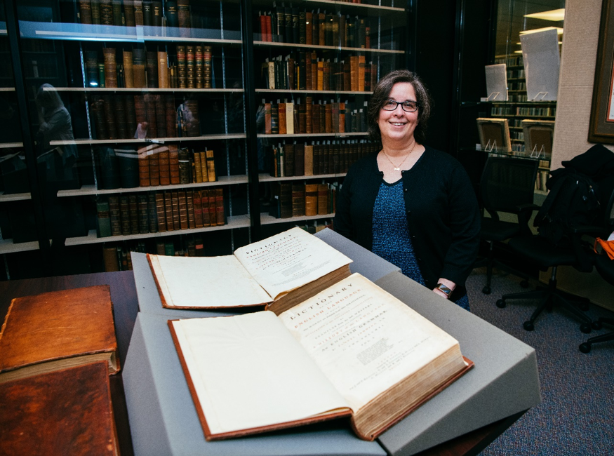 Dr. Young sitting with original volumes of Johnson’s Dictionary. .