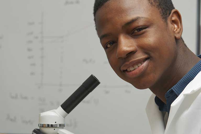 African-American student at a microscope