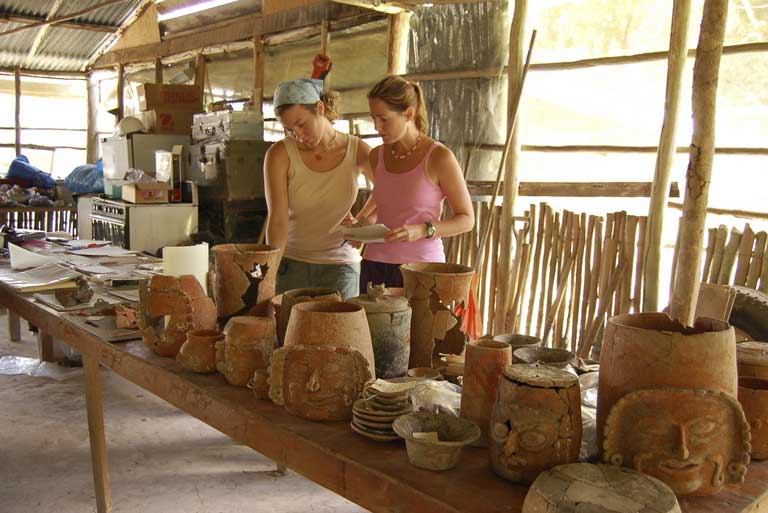 Students examining ancient Mayan pottery